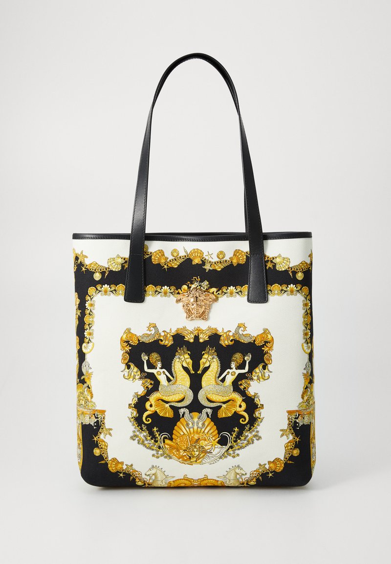 Borsa a tracolla con manici in pelle nera, tela bianca con un design ornamentale oro e nero, motivo del cavalluccio marino e un emblema decorativo.