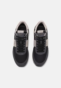 Meeste tossud mustast võrgust ja nahast, hallide aktsentidega, ümarate paeltega ning ülemise osa beezist paneeliga, mis lisab detaili.