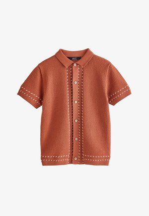 Kurzärmeliger, rostfarbener Strickcardigan mit Kragen, Knopfleiste vorne und weißen Ziernähten an Ärmeln, Vorderseite und Saum.