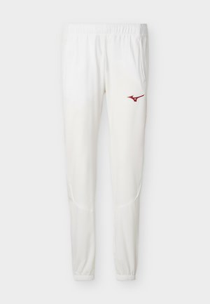 Valged spordipüksid, millel on elastne vöökoht ja soonikkäärid, kahe jala paremal reiel väike punane Mizuno logo.