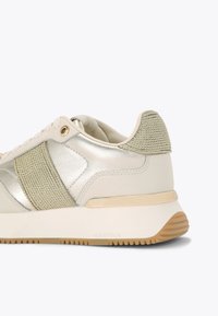 Jasne sneakersy z metalicznymi akcentami, szczegółami z teksturowanej tkaniny oraz beżową podeszwą. Posiadają gładkie skórzane wykończenie oraz logo na pięcie.