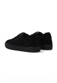 Czarne zamszowe sneakersy z teksturowaną cholewką, niskim profilem, płaskimi sznurowadłami, wzmocnionym piętem i gumową podeszwą. Widok z tyłu pokazuje projekt.