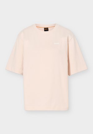 Camiseta de manga corta y cuello redondo en beige claro con pequeño logo blanco "BOSS" en el pecho izquierdo y etiqueta negra en el cuello con detalle en naranja.