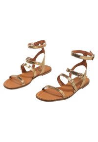 Sandalias metálicas doradas con diseño de estampado de serpiente, que cuentan con tres tiras y hebillas en el tobillo. Suela plana marrón con plantilla texturizada.