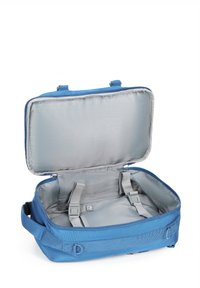 Modrá cestovní taška se zipovým uzávěrem. Vnitřek má světle šedou vzorovanou podšívku a nastavitelné upevňovací popruhy.