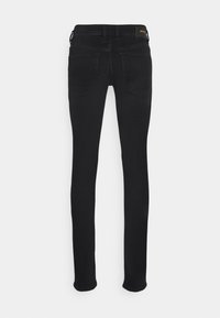 Svarta skinny jeans med en slät denimtextur, femficksdesign och subtila sömdetaljer. Har en logotyppatch vid midjan.