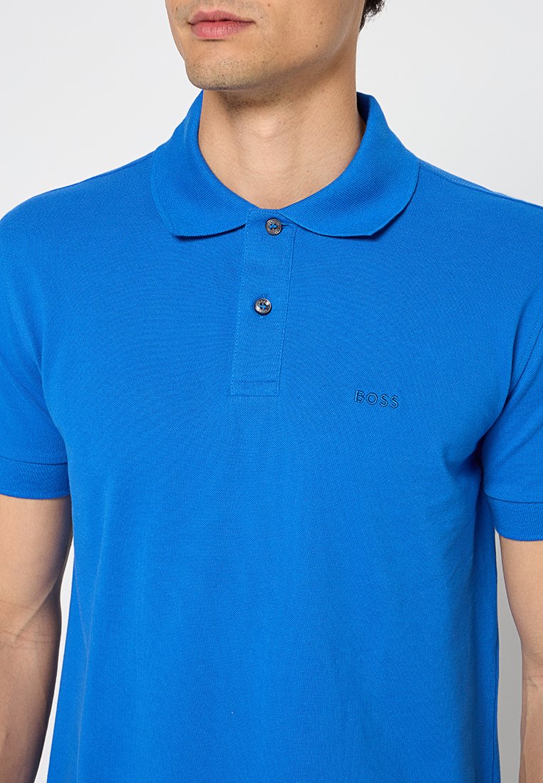 Blauwe katoenen polo met een klassieke kraag, een twee-knopsluiting en subtiele geborduurde logo op de borst. Korte mouwen en een gestructureerde stof.
