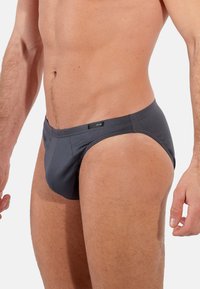 Graue Herrenunterhosen aus weichem, elastischem Material. Sie verfügen über ein tief sitzendes Design mit einem definierten Pouch und minimalen Nähten für zusätzlichen Komfort.