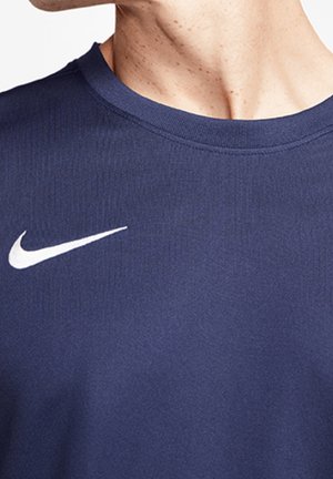 Navyblå atletisk t-shirt lavet af blødt stof, med rund halsudskæring og et hvidt Nike-logo på venstre brystområde.