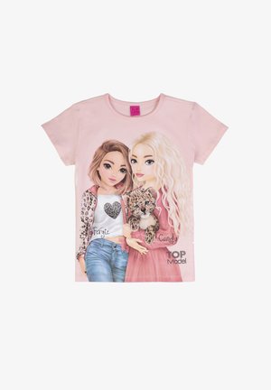 Two animated girls, one with brown hair in casual clothes, the other with long blonde hair holding a leopard cub, on a pink shirt.