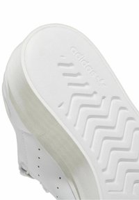 Vita sneakers med en strukturerad sula som har zigzagmönster. Designad med slätt läder och en distinkt logotyp präglad på yttersulan.