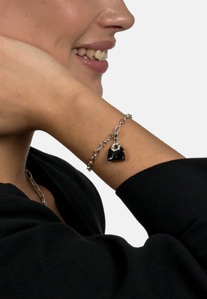 Silver chain bracelet featuring a black charm with a circular accent. The bracelet has an alternating link design and a smooth finish.