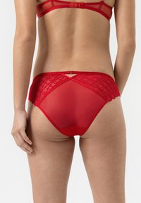 Rode kant en gaas bikini met een gegolfde rand, voorzien van een diamantpatroon op de rug en een band met een kleine metalen accent.