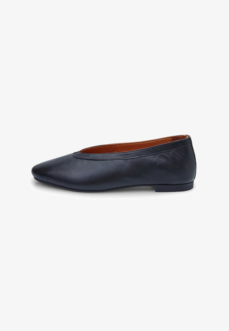 Bailarinas de cuero negro con punta afilada, textura suave y diseño minimalista. Cuentan con una suela delgada y flexible y un sutil forro marrón.