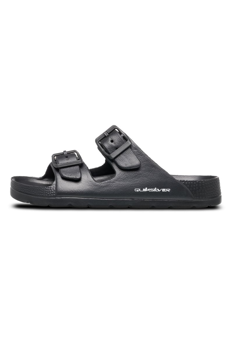 Sorte sandaler lavet af struktureret materiale med to justerbare remme, hvor hver har firkantede spænder. Sålen er flad med et skridsikkert mønster.