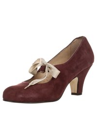 Scarpa con tacco alto in suede bordeaux, con punta arrotondata e un fiocco di raso crema al centro, caratterizzata da un tacco di media altezza e dettagli minimi.
