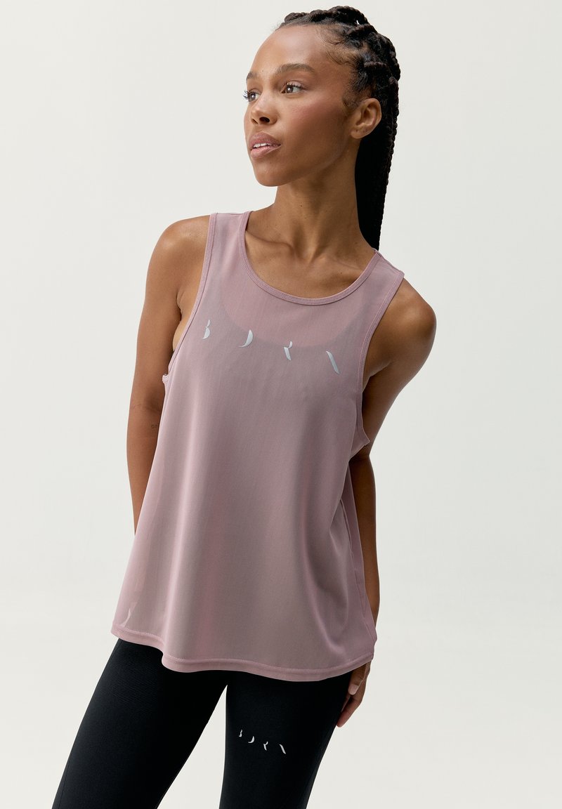 Lekki, bezrękawnik w kolorze różowym o luźnym kroju, z srebrnym napisem. Połączony z czarnymi legginsami z wycięciami.