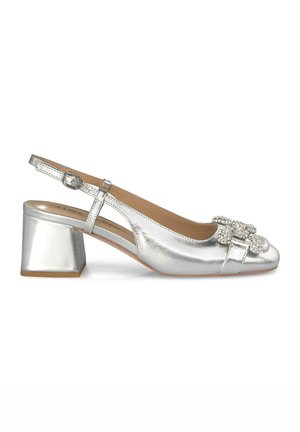Scarpa slingback metallica argento con tacco a blocco, punta arrotondata e fiocco decorativo con strass sulla parte anteriore. Texture liscia, design minimale.