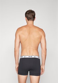 Schwarze Boxer-Shorts aus elastischem Material, mit einem weißen Nike-Label am Bund und einem enganliegenden Design.