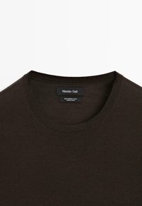 Pull à col rond marron foncé en laine mérinos 100 % avec une étiquette de la marque Massimo Dutti à l'intérieur du col.