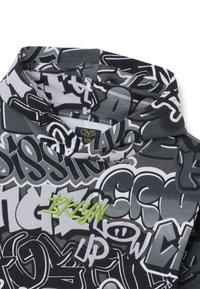 Sudadera negra y gris con un estampado de estilo graffiti. Incluye un "BKLYN" bordado en verde brillante, con una textura de tela suave.