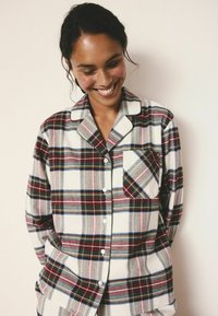 Rutet button-up skjorte med en blanding af røde, blå og grå striber, med en brystlomme og en blød tekstur. Klassisk kravedesign.