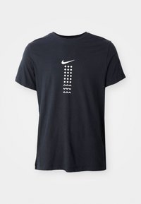 Juodas medvilninis marškinėlis su baltu Nike logotipu ir vertikaliai išdėstytais geometriniais raštais kontrastingomis baltomis spalvomis. Paprastos apvalios iškirptės dizainas.