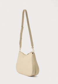 Μπεζ δερμάτινη τσάντα ώμου με καμπυλωτό σχήμα, ρυθμιζόμενο λουράκι, χρυσές μεταλλικές λεπτομέρειες και υφή στην επιφάνεια.