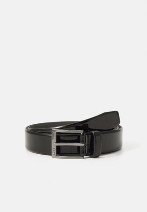 Ceinture en cuir vernis noir avec une finition brillante, dotée d'une boucle en métal argenté de forme rectangulaire et d'une boucle robuste pour le réglage.