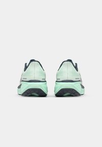 Helle mintfarbene Laufschuhe mit einem strukturierten Mesh-Obermaterial, gepolsterten Sohlen und dunklen Grautönen; die Rückansicht zeigt die Stabilitätseigenschaften der Ferse.