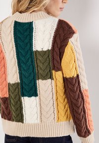 Sweter dzianinowy z wzorem patchworkowym, z kolorowymi panelami w odcieniach zieleni, brązu, żółci, kremu i koralu, o fakturze ze splotem w warkocze.