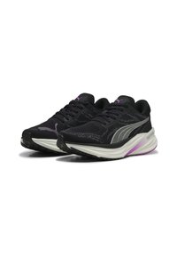Baskets de sport noires avec une tige en mesh, des accents violets, une semelle arrondie et une texture antidérapante sur la semelle extérieure pour une meilleure traction.