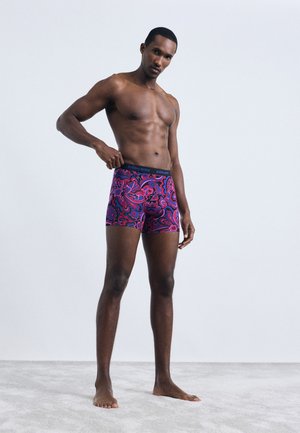 Men's underwear in purple with vibrant pink and blue paisley pattern. Stretchy fabric and elastic waistband with "BJÖRN BORG" logo.