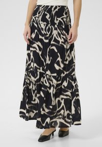 Gonna maxi con stampa astratta in bianco e nero, caratterizzata da una vita smock, design a strati e tessuto fluido. Indossata con tacchi neri.