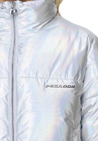 Glänzende silberne Steppjacke mit hohem Kragen, Frontreißverschluss und "PEGADOR"-Logo auf der Brust. Glattes, reflektierendes Material mit minimalen Nähten.
