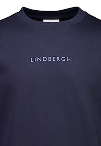 Mörkblå sweatshirt med rund halsringning; har diskret texten "LINDBERGH" i ljusblått över bröstet. Mjuk, slät textur.