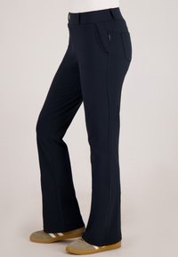 Donkerblauwe, rekbare broek met een uitlopende pasvorm, een tailleband met lusjes en een ritszak aan de zijkant. Zachte textuur, casual pasvorm.