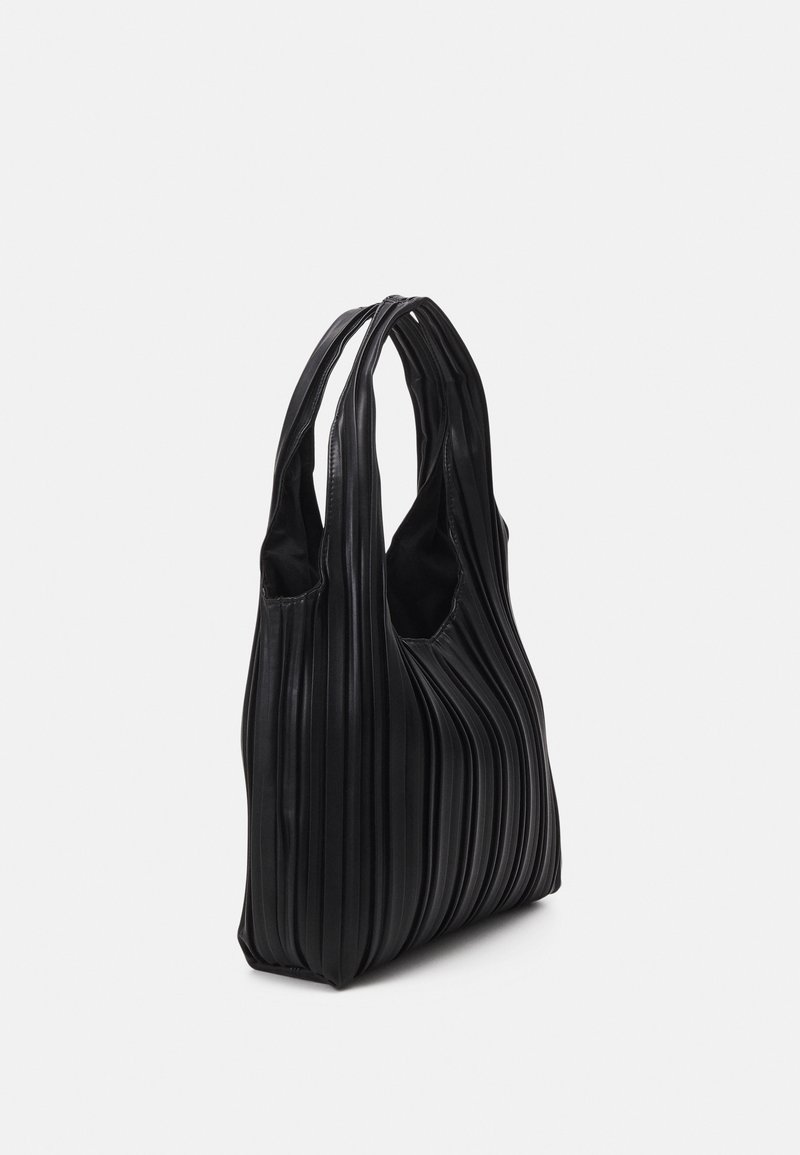 Sac cabas noir plissé avec doubles poignées, texture douce et fond arrondi et souple sur un fond clair uni.