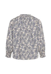 Blouse à manches longues avec un fond clair et un motif floral bleu dense, avec des poignets froncés et des plis dans le haut du dos.