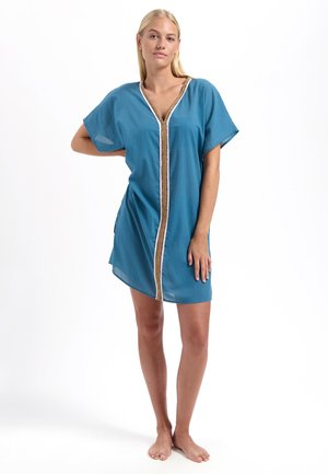 Kaftan in cotone turchese con maniche corte e scollo a V, caratterizzato da un bordo a strisce dorate e bianche lungo la parte anteriore e fessure laterali.