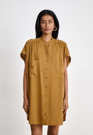 Vestito camicia giallo senape a maniche corte con bottoni frontali, spalle plissettate e due tasche sul petto. Tessuto a strisce verticali.