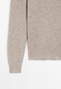 Maglione marrone chiaro a coste con maniche lunghe e motivo a maglia strutturata, con orlo dritto sul fondo.