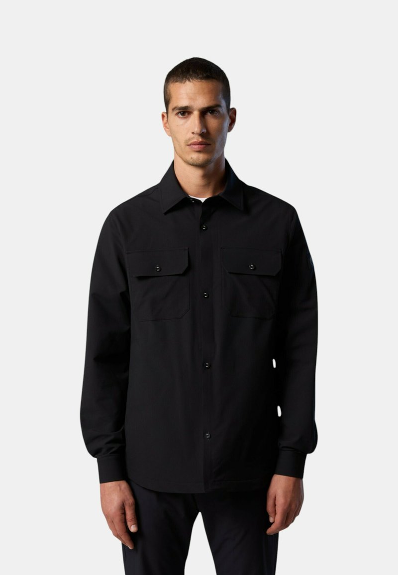 Camicia nera con bottoni e maniche lunghe, due tasche sul petto e taglio dritto. Il tessuto sembra liscio, con una finitura opaca.