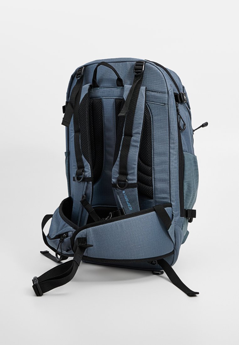 Blauer gepolsterter Rucksack von hinten gezeigt, mit verstellbaren Schultergurten, Netzrückenpaneel, Seitentaschen und Hüftgurt mit Reißverschlusstasche.