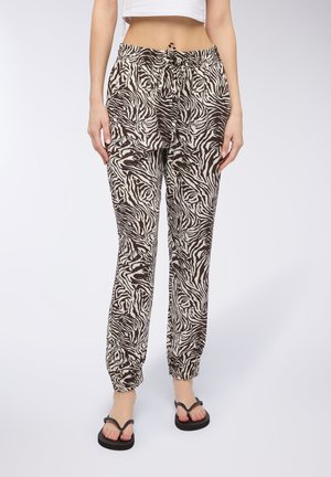 Joggers a righe zebra marrone e crema con vita elastica, tasche laterali e caviglie elastiche, realizzati in un tessuto leggero.