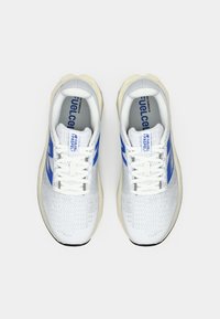 Baskets blanches avec des accents bleus, tige texturée, bout rond et lacets plats. Semelle en caoutchouc épaisse crème. Présente le logo de la marque à l'arrière.