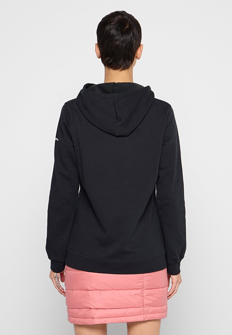 Schwarzer Kapuzenpullover mit glatter Textur, ausgestattet mit einer Kängurutasche und gerippten Bündchen, kombiniert mit einem leicht rosa Pufferrock.