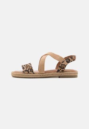Tan Espadrillesandalen mit Gepardendruckakzenten, die ein Kreuzriemendesign und eine gewebte Jutesohle aufweisen. Offene Zehen- und Rückseite für Komfort.