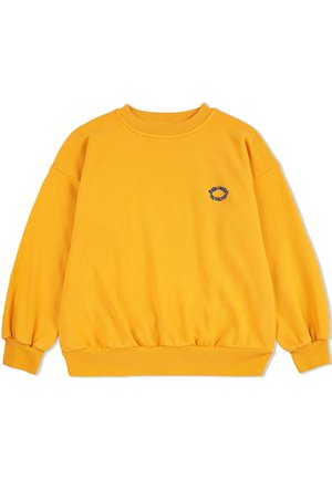 Żółta bluza z okrągłym dekoltem i luźnym krojem. Posiada ściągacze na rękawach i dolnym brzegu oraz małe, niebieskie haftowane logo na piersi.