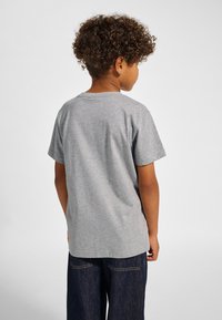 Grå kortärmad t-shirt i mjuk bomull, med rund halsringning och rak skärning. Synliga sömmar och avslappnad passform.